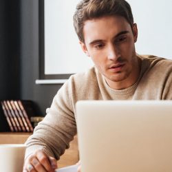 a young millennial checking his finances and debt