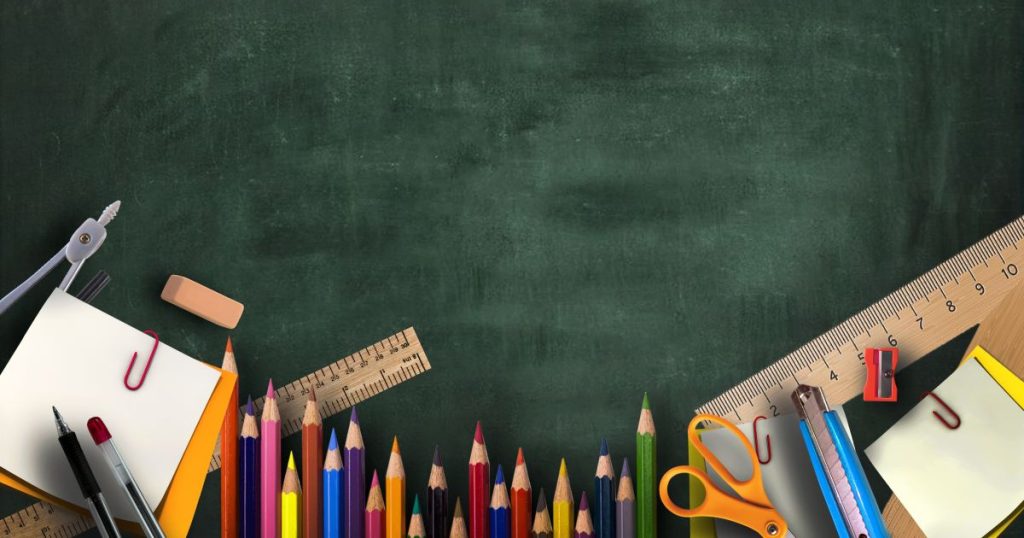 Various school supplies arranged on chalkboard green background