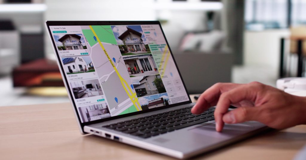 A person views an online real estate location search on their laptop.